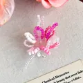 Dettaglio macro di un ciondolo a fiore in perline rosa e bianco fatto a mano per sabot - Combinazione Multimateriale Stile Principessa Viola Rosso (27965-13)