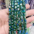 Detailed view of 8x9mm faceted green glass crystal cylinder beads for DIY jewelry. - Cylinder / Peacock Green AB