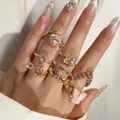 Gros plan exquis de bagues en or avec papillon rose et cœur en cristal sur main - Style Cœur Saturne Papillon (32742-ring-pink-EP)