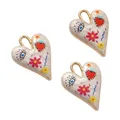 Detailed view of white enamel heart pendants with hand-painted floral and eye motifs - 35*26mm / Style 7