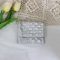 Detailed close-up view of a metallic silver quilted checkerboard pattern mini pouch - Silver Small Grid