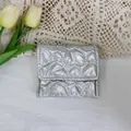 Macro view of silver heart-quilted PU leather pouch showing the button closure. - Silver Heart