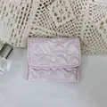 Detail view of a pink heart-quilted mini pouch for organizing coins and small cosmetics - Pink Heart