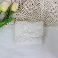 Close-up of white quilted PU heart-patterned small storage pouch with snap button - Off-white Heart