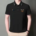 Nahaufnahme eines schwarzen Herren-Polo-Shirts mit Bruststickerei und Streifenkragen - M / Schwarz