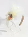 Serre-tête de mariée élégant en plumes blanches avec fleur en cristal et résille. - Grand Nœud Plume Beige
