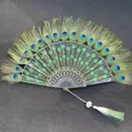 Close-up of a peacock feather folding fan with green floral embroidery and tassel - Single Piece / Green (Peacock Feather Embroidery Style)