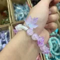 Purple beaded bracelet with lavender glitter maple leaf and flower charms worn on a hand - Fallen Maple Leaf Purple
