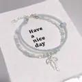 Elegant forest style beaded bracelet with silver bow charm in light blue - Ballet Style Bow Seed Bead Blue