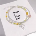 Forest style beaded bracelet featuring a silver bow charm and mixed yellow and white beads - Ballet Style Bow Seed Bead Yellow