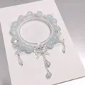 Handmade forest style light blue crystal beaded bracelet featuring butterfly and bow charms - Bow Tassel Crystal Blue