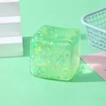 Detail shot of a green translucent cube squishy toy with shimmering glitters inside - Green Glitter Cube