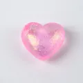 Detailed view of a pink heart-shaped squishy toy filled with shimmering colorful glitter. - OPP Bag / Pink