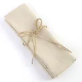 Beige cotton linen napkin folded and tied with a rustic jute twine bow for table decor. - Flaxen