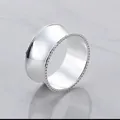 Elegant silver metallic napkin ring with beaded edges on a marble surface background - Fine Beaded Edge Style / Silver
