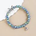Elegant blue and green marbled ceramic beaded bracelet featuring a silver butterfly charm - Diexi Blue Green Bell Butterfly (1784-01)