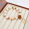 Elegant handcrafted ceramic beaded bracelet featuring a pink bear charm and wooden star accent - Pink Bear and Pentagram (1785-02)