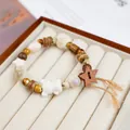 Handmade ceramic beaded bracelet with wooden star charm in a classic jewelry display tray - Coconut Rice Ball White Bear Tassel (1785-01)