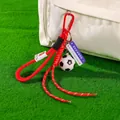 Creative soccer ball paracord keychain charm on green grass background - Classic Soccer Ball + Red Braid Rope + Carabiner