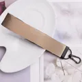 Porte-clés en ruban tissé beige durable avec fermoir en métal noir pour sac à dos - café