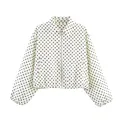 Gros plan d'une veste à pois pour femme avec fermeture éclair et poignets élastiques. - Blanc à pois