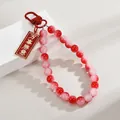 Red and pink gradient beaded bag charm with auspicious gold-bordered pendant - Everything As Desired