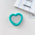 Close-up detail of a teal silicone heart-shaped phone grip featuring a built-in mirror - Lake Blue