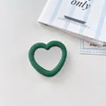 Detail shot of a dark green heart-shaped silicone phone grip with integrated vanity mirror. - Dark Green