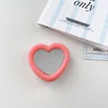Makroansicht des rosa herzförmigen Silikon-Handygriffs mit einer klaren Spiegelfläche - Dunkelrosa