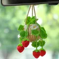 Close-up of a handmade crochet strawberry plant ornament hanging from a car rearview mirror - Fluorescent Green Strawberry