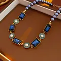 Vintage court style necklace with blue rectangular crystals and pearls in a jewelry box. - Gold Blue Rectangular Gem Necklace