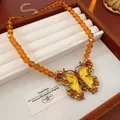 Detailed view of a vintage palace style butterfly necklace with amber beads - Gold Yellow Amber Bead Butterfly Necklace