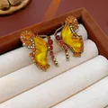 Close-up of vintage butterfly earrings with amber rhinestones in a brown jewelry box - Golden Butterfly Rhinestone Earrings / Silver Earring Post - Gold - Yellow