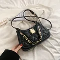 Elegante bolso de hombro acolchado negro con una cadena dorada y hebilla metálica - Triángulo Negro