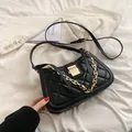 Elegante bolso de hombro acolchado negro con detalles de cadena dorada y correa. - Patrón de Diamantes Negro