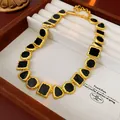 Vintage style gold-toned necklace featuring black geometric enamel insets in jewelry box - Gold Black Geometric Necklace
