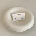Close-up view of blue mini candy bean stud earrings presented on a minimalist card - Sky Blue