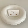 Detailansicht von minimalistischen Mini-Ohrsteckern in Bonbonfarben auf einer Dankeskarte. - Milchtee-Farbe