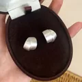 Close-up van matzilveren oorbellen met geborstelde textuur in een fluwelen doos - Zilver