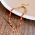 Elegante bracciale a cordino rosso placcato oro 18 carati con perline metalliche SKU - Oro e Rosso
