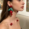 Vintage red cherry drop earrings with green leaf detail on model - Cherry Green Tassel Earrings (2606066)