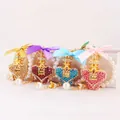 Set of 4 elegant crystal heart perfume bottle keychains with ribbon bows and pearl charms. - Random Color