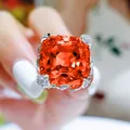 Detailed macro shot of a vibrant Asscher cut orange gemstone ring with flower setting - Adjustable Open / Fanta Orange