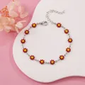 Detail view of a dainty silver daisy bracelet with vibrant red and yellow petals. - Red Daisy (Silver Tone)