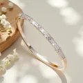 Macro view of gold-tone bangle with pavé-set crystals and cross motif - Style D Silver