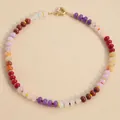 Colorful natural stone beaded choker necklace with gold spring ring clasp on beige background - Light Color