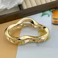 Detalle de pinza para el cabello grande de metal dorado con forma de nube ondulada - 11cm / Dorado