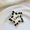 Detailansicht einer weißen Haarspange in Sternform mit schwarzer Wolle und 'Like' Text - Weiße Stern Haarklammern