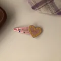 Close-up of pink heart hair clip with yellow dots and LOVE engraving in detail - Pink Heart BB Clip