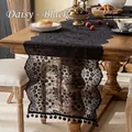 Elegant black French lace table runner with hollow floral patterns and pom-pom trim - Daisi Black